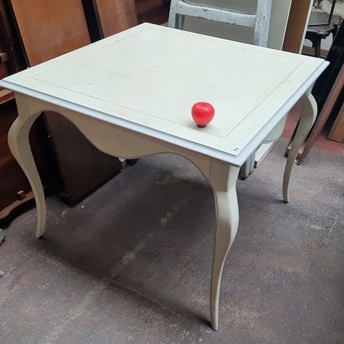 864 - A white-painted wooden table with curved legs, featuring a square top.