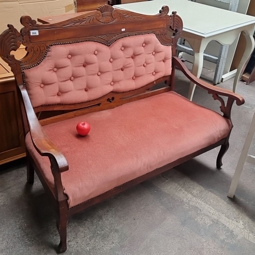 866 - A Victorian carved wooden settee with upholstered back and seat, featuring intricate detailing and p... 