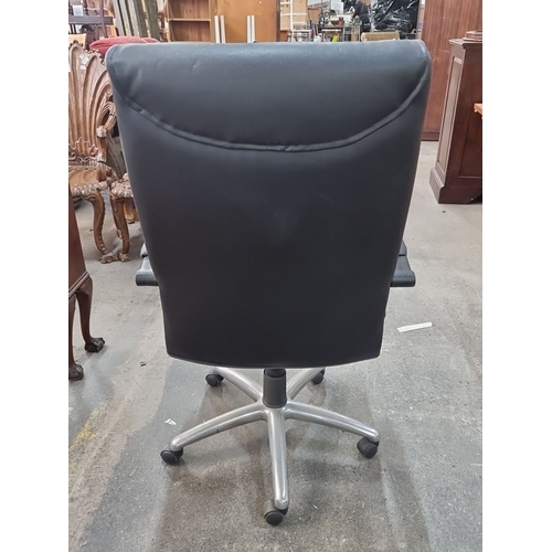 867 - A black leather swivel office chair with adjustable armrests and silver five-pointed base on castor ... 