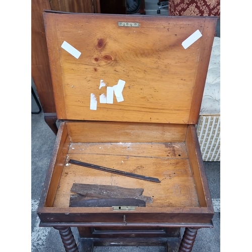 869 - A Victorian mahogany Davenport desk featuring a sloped writing surface, turned supports, and interio... 