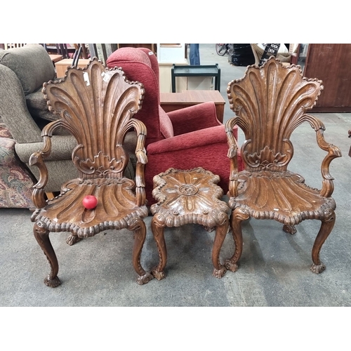 871 - Star lot..Two intricately carved wooden chairs and a matching table, featuring ornate shell and scro... 