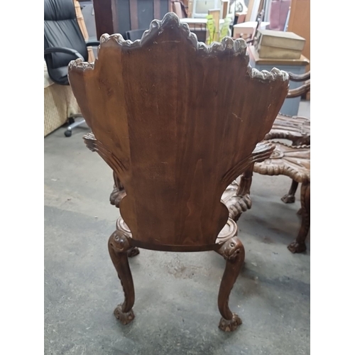 871 - Star lot..Two intricately carved wooden chairs and a matching table, featuring ornate shell and scro... 