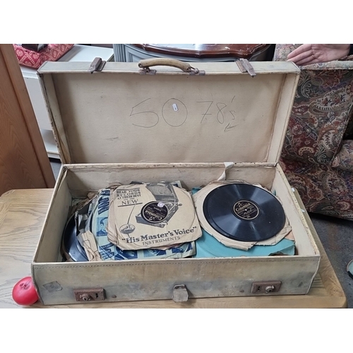 873 - A vintage suitcase containing approximately 50 assorted 78 RPM records, featuring labels such as 