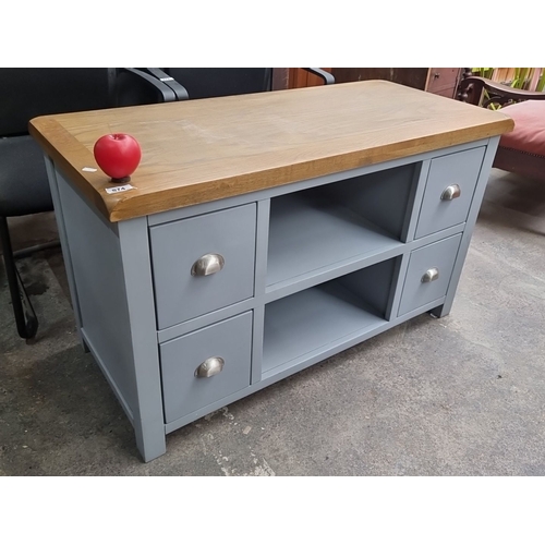 874 - A Casamoré TV stand  with oak top and grey-painted wooden frame. Features four drawers and two open ... 