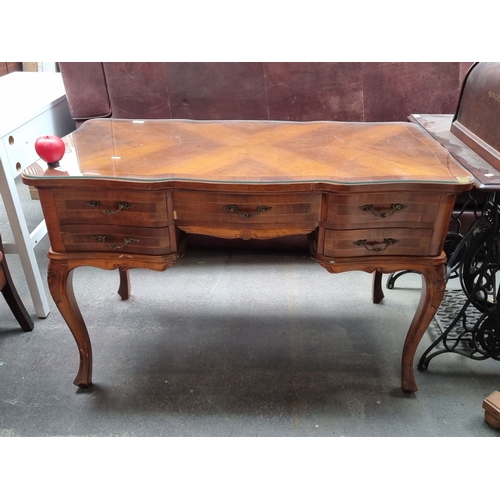 876 - Star lot..An gorgeous wooden desk featuring ornate cabriole legs, a curved front, and four drawers. ... 