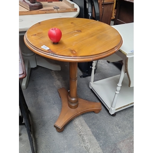 878 - Solid pine round side table with pedestal base, featuring a natural wood grain finish.