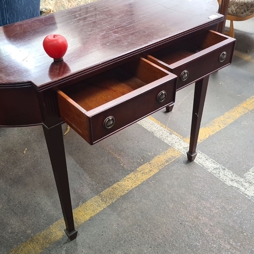 856 - Dark mahogany console table with two drawers, featuring brass ring handles and tapered legs. Appears... 