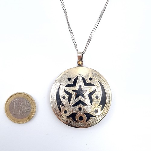 32 - An Asian pendant set with star motif with gold & sterling silver mounts set in onyx stone with silve... 