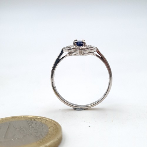 936 - An 18 carat gold blue sapphire gemstone ring set with diamond surround. Ring size - N. Weight - 2.76... 