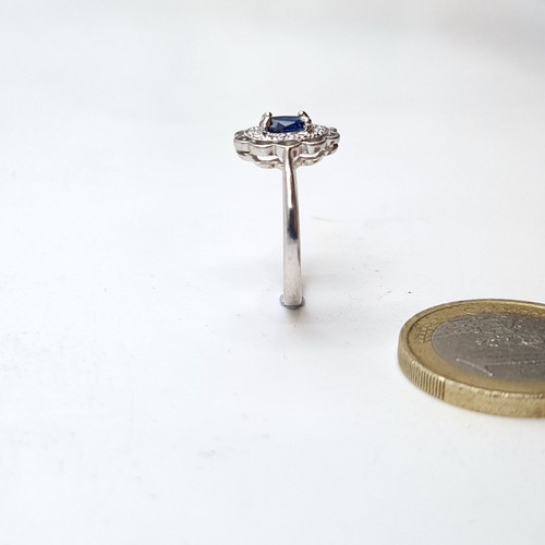 936 - An 18 carat gold blue sapphire gemstone ring set with diamond surround. Ring size - N. Weight - 2.76... 