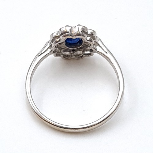 936 - An 18 carat gold blue sapphire gemstone ring set with diamond surround. Ring size - N. Weight - 2.76... 