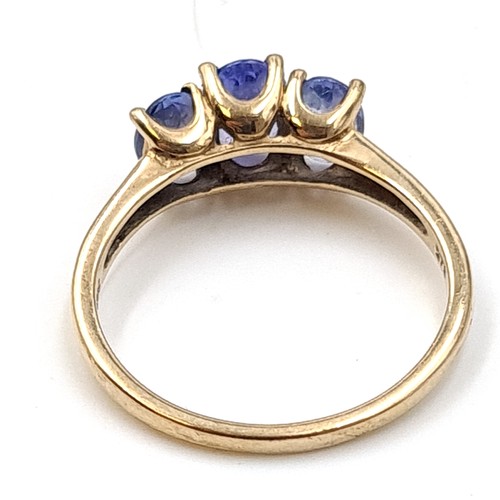 937 - Star Lot : A nine carat gold (375) three stone Tanzanite ring. Ring size - O. Weight - 2.08 grams. B... 