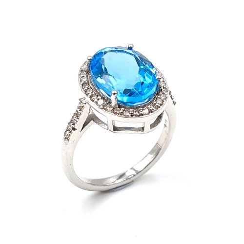 47 - A blue topaz and diamond gemstone ring mounted in sterling silver with diamond surround. Size - O. W... 
