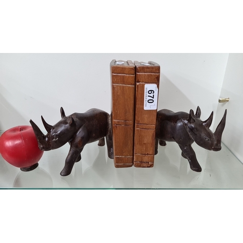 670 - A pair of heavy weight carved wooden rhinoceros bookends with a faux book design. The set includes t... 