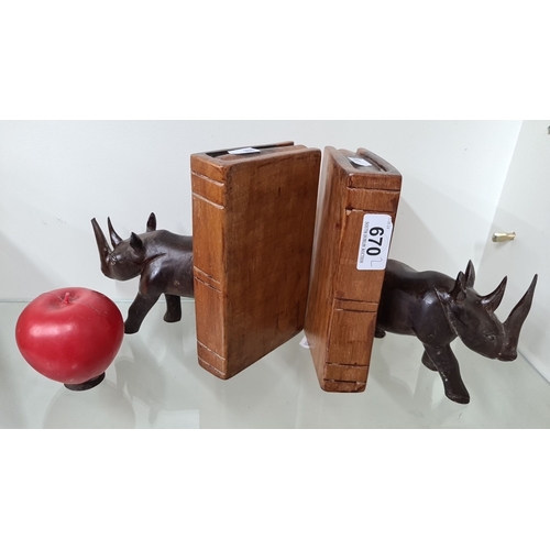 670 - A pair of heavy weight carved wooden rhinoceros bookends with a faux book design. The set includes t... 