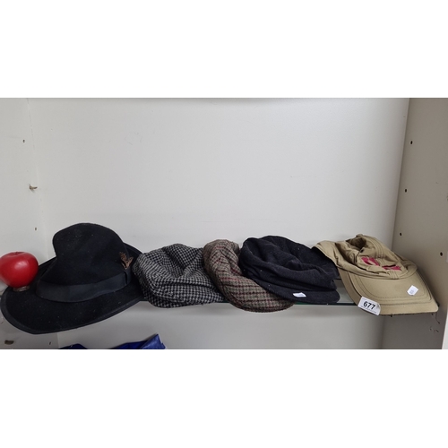 677 - A selection of five assorted hats, including a black fedora with feather detail,  two flat caps, and... 