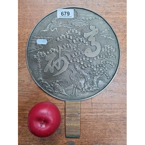 679 - A vintage Japanese brass hand embossed mirror with engraved crane and pine tree motif, featuring Asi... 