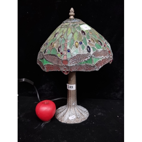 249 - A gorgeous Tiffany style table lamp. The shade exhibits lush shades of green and red with hints of b... 