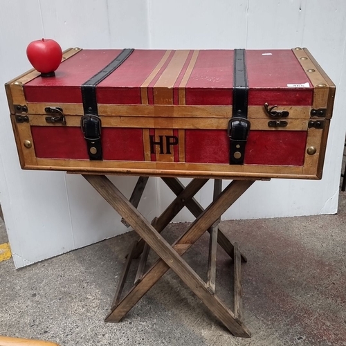 465 - A HARRY POTTER Antique-style red trunk with wooden trim and black leather straps, featuring 