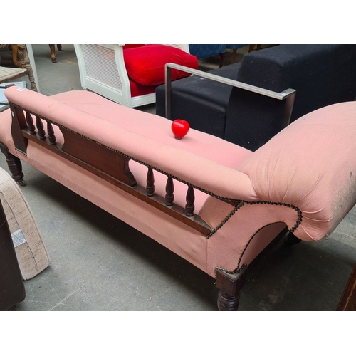 970 - A Victorian chaise longue featuring turned wood legs and ornate carved detailing, upholstered in pin... 