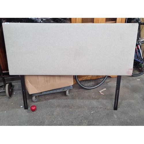 974 - An as new Light grey upholstered headboard with black metal legs, approximately 3 feet in height.