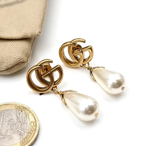 904 - A Gucci Interlocking flower pearl earrings. Features metal with gold finish and interlocking G detai... 