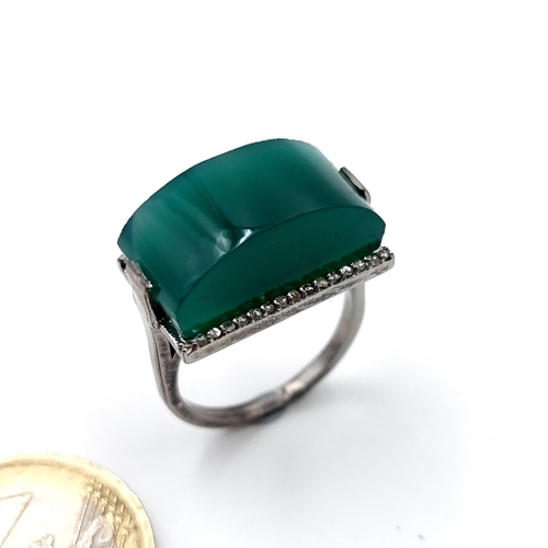 917 - A green tourmaline stone ring. Stone 14 carats with diamond setting - 0.29 carats. Ring size - Set I... 