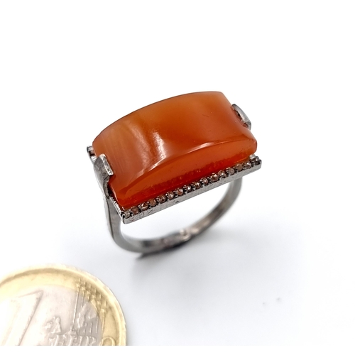 918 - Star Lot : A very unusual carnelian stone ring of 14 carats. Together with a diamond surround of 0.2... 