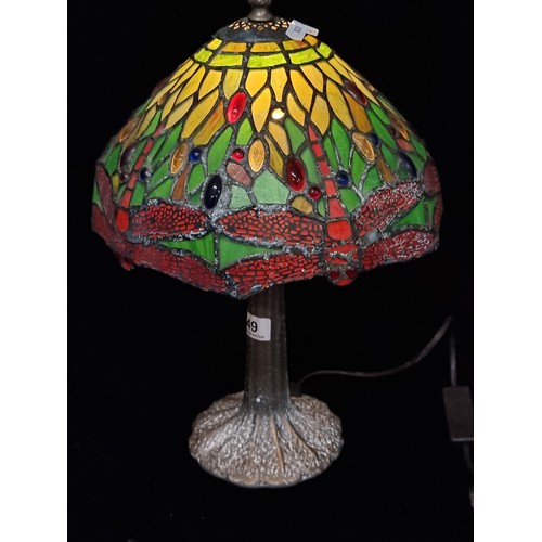 249 - A gorgeous Tiffany style table lamp. The shade exhibits lush shades of green and red with hints of b... 