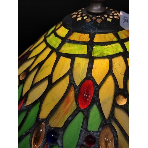 249 - A gorgeous Tiffany style table lamp. The shade exhibits lush shades of green and red with hints of b... 