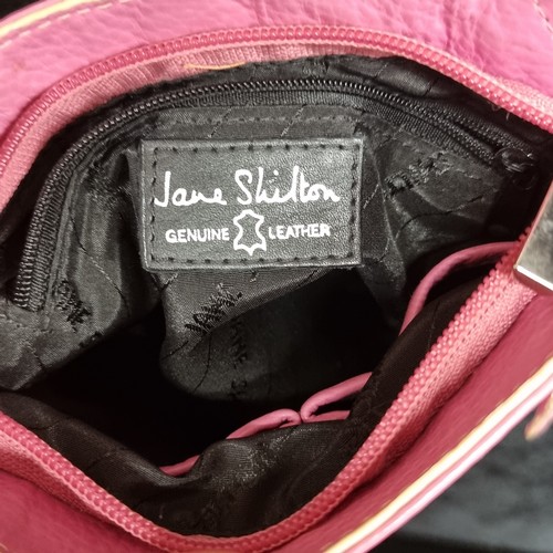 277 - A Jane Shilton genuine leather small crossbody messenger bag. Pink leather with a cream strap. In ve... 