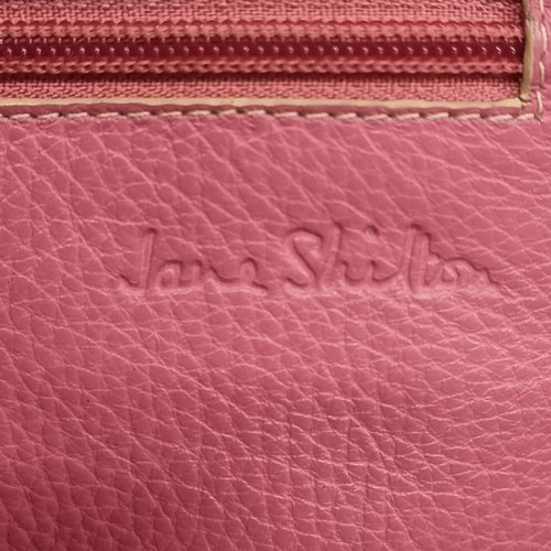 277 - A Jane Shilton genuine leather small crossbody messenger bag. Pink leather with a cream strap. In ve... 