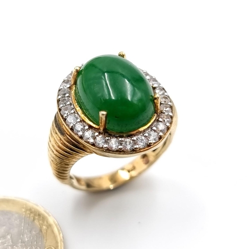 41 - A silver gilt jade cabochon stone ring with gem set surround. Ring size - P. Weight - 9.12 grams.