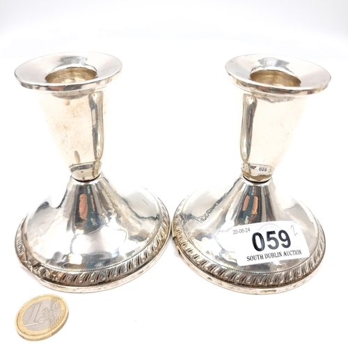 59 - A pair of sterling silver candle holders marked sterling to base. Dimensions: Base - 9 cms diameter.... 