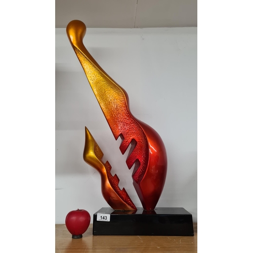 143 - An abstract large flame sculpture in the from of a guitar mounted on a wooden plinth