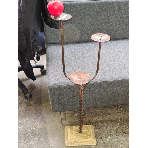 A striking three tier floor standing pillar candle holder featuring a