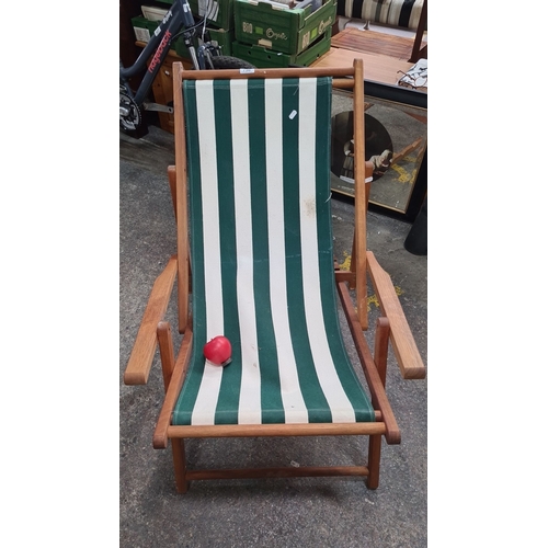 730 - Teak wood deck chair with green and white striped canvas folds up to almost flat.