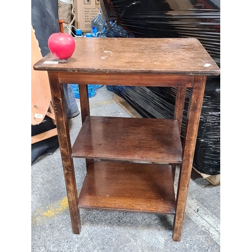 734 - An early 20th-century wooden side table, likely oak, featuring three-tier shelving.