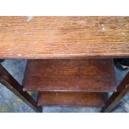 734 - An early 20th-century wooden side table, likely oak, featuring three-tier shelving.