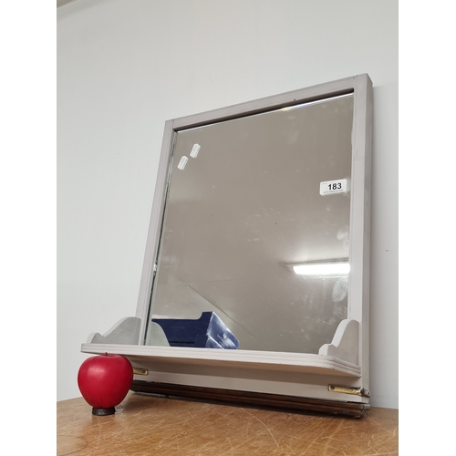 183 - A wall mounted bathroom mirror featuring a practical shelf.