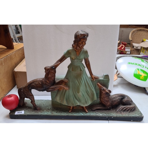 408 - A large art deco cast figure of a lady with two dogs, Dimensions: 14 inches wide.