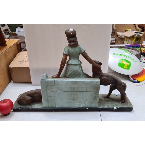 408 - A large art deco cast figure of a lady with two dogs, Dimensions: 14 inches wide.