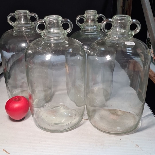 428 - Set of four large glass demijohns. Perfect for wine making / brewing enthusiasts. Approximately 3-4 ... 