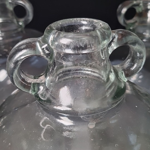 428 - Set of four large glass demijohns. Perfect for wine making / brewing enthusiasts. Approximately 3-4 ... 