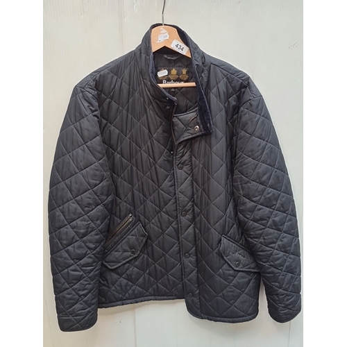 434 - A black quilted Barbour jacket with zip and button closure, size L. In good order.