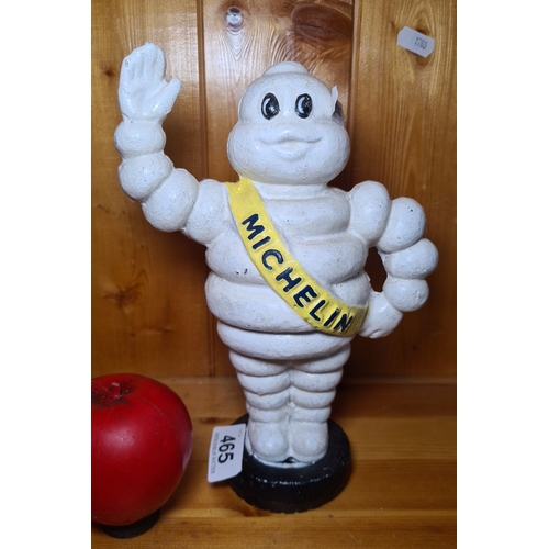 465 - An iconic Michelin Man cast iron coin bank. Painted in classic white with a yellow sash marked 