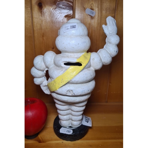 465 - An iconic Michelin Man cast iron coin bank. Painted in classic white with a yellow sash marked 