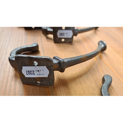 470 - A set of six antique wrought iron wall hooks, showcasing a rustic design and sturdy construction.