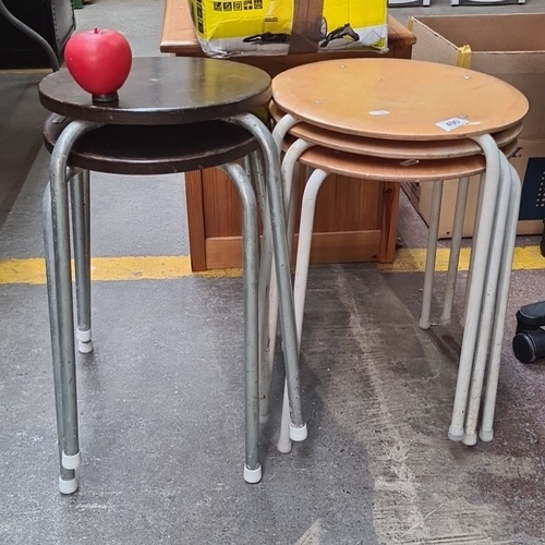 490 - A set of five mid-century modern stacking stools, featuring metal legs and circular wooden seats in ... 