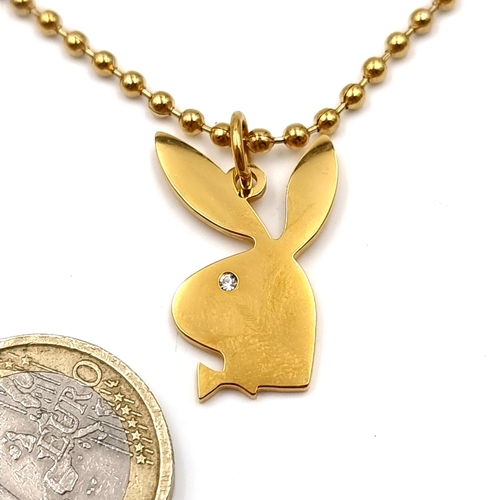 26 - A gold metal necklace with a playboy bunny pendant set with gemstone accents. Length of chain - 64 c... 